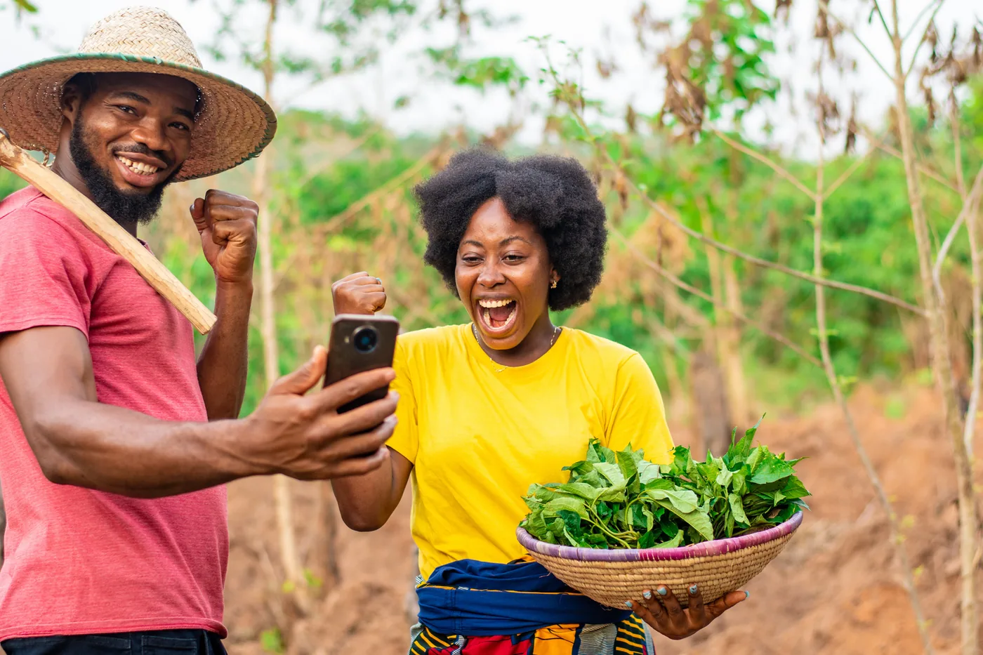 Two farmers celebrating after receiving payment on their phone